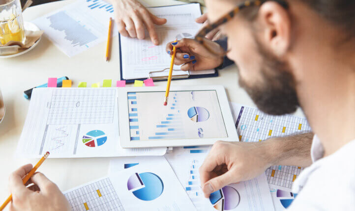 three colleagues analysing business charts and statistics