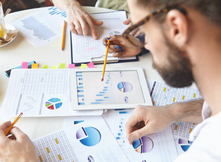 three colleagues analysing business charts and statistics